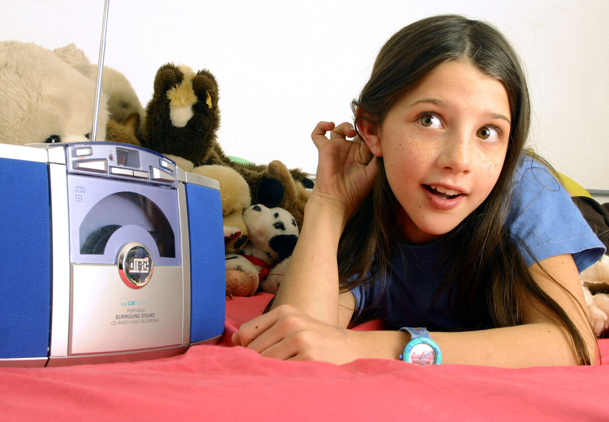 Kind hört auf dem Bett Radio